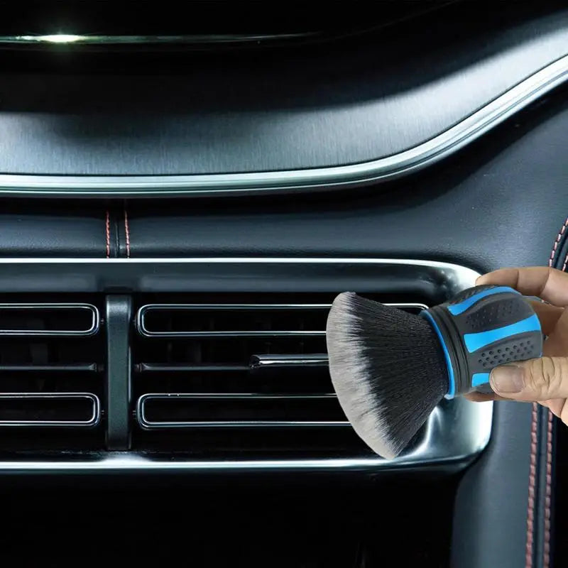 a person cleaning a car dashboard with a brush