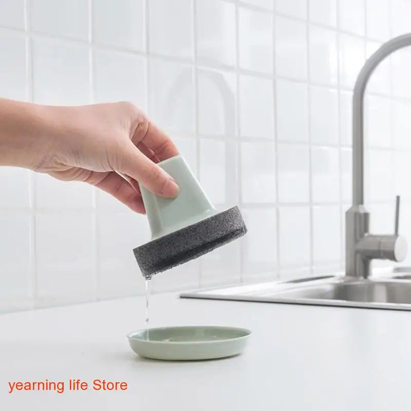 a person cleaning a kitchen sink with a sponge