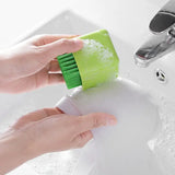 a person cleaning a sink with a green brush