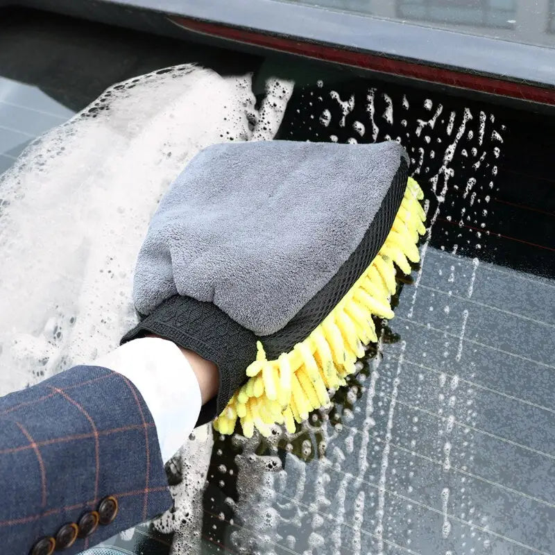 a person cleaning a car with a sponge