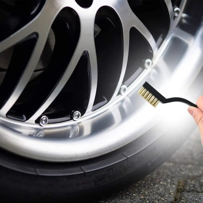 a person is cleaning a tire with a brush