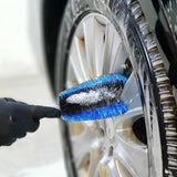 a person cleaning a car tire with a brush