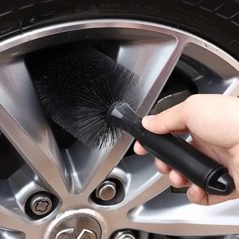 a person cleaning a tire with a brush