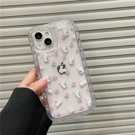 A person holding a clear case with pink flowers and white butterflies