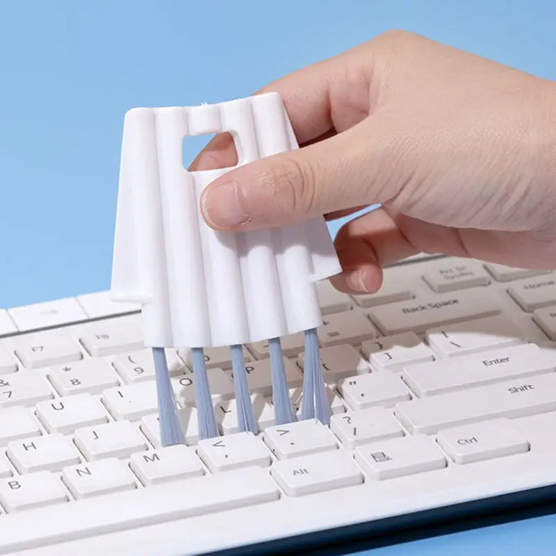 a hand is holding a white plastic object on a keyboard