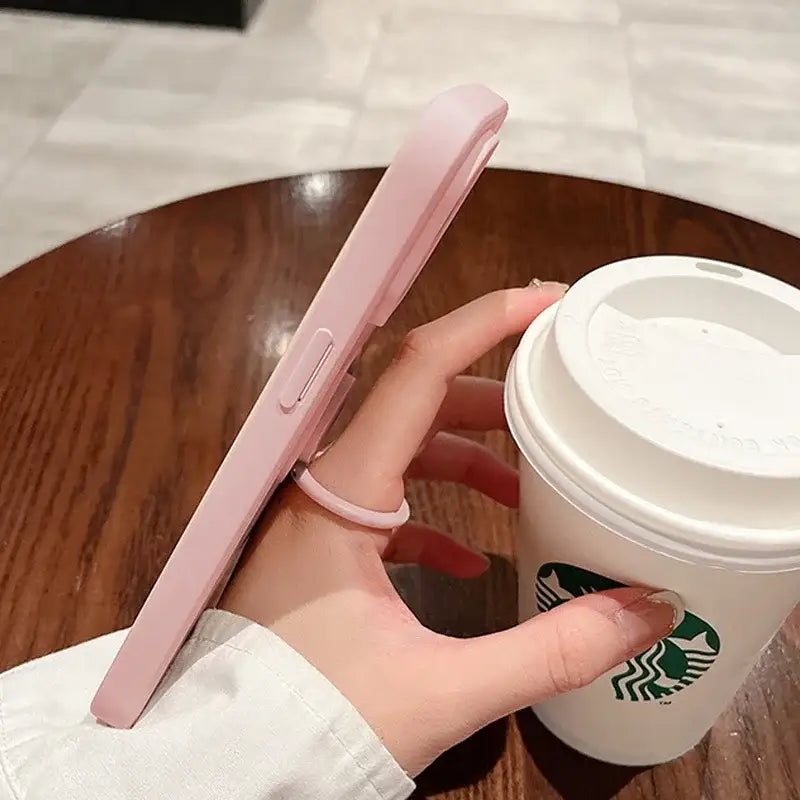 a person holding a cup with a pink handle