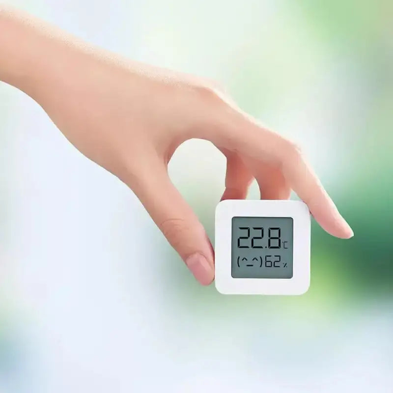 a person holding a digital therm