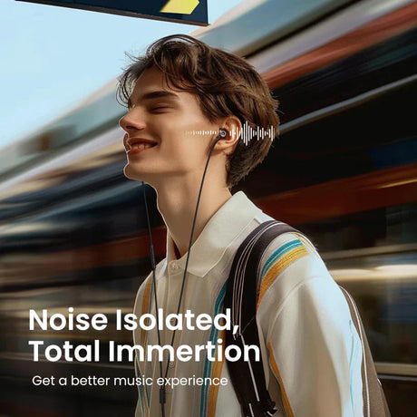 Person wearing earbuds and smiling while standing near a blurred train or subway.