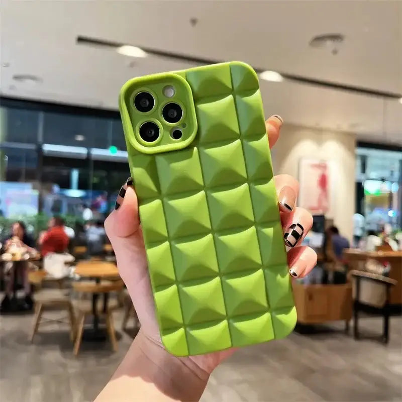 a person holding a green phone case