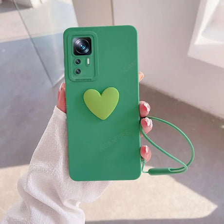 A person holding a green phone case with a heart on it