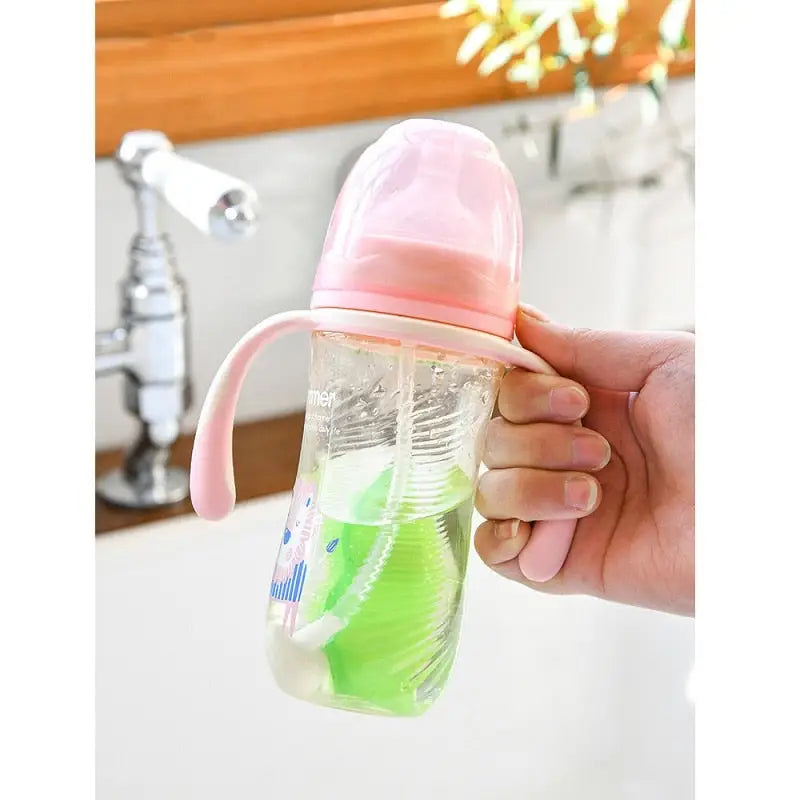 a person holding a baby bottle in their hand