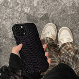 a person holding a black iphone case