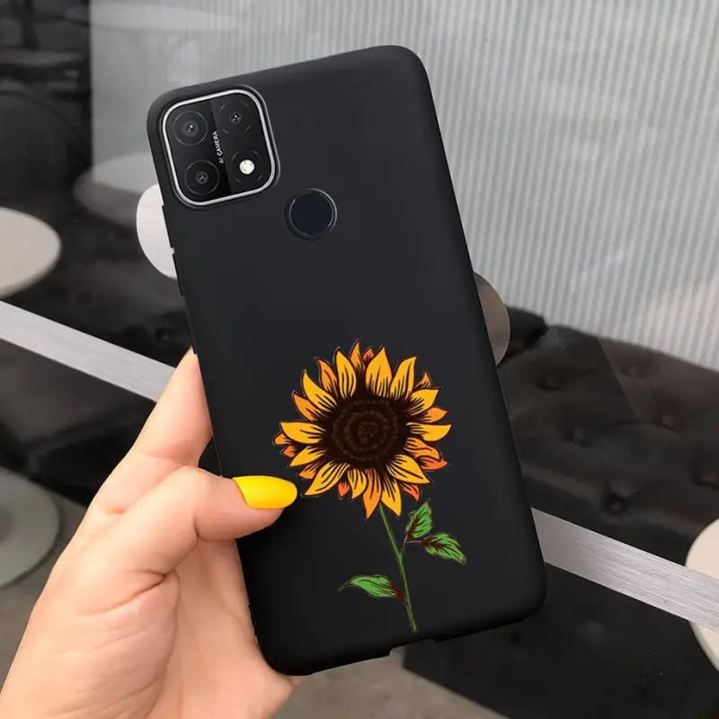 a hand holding a phone case with a sunflower on it