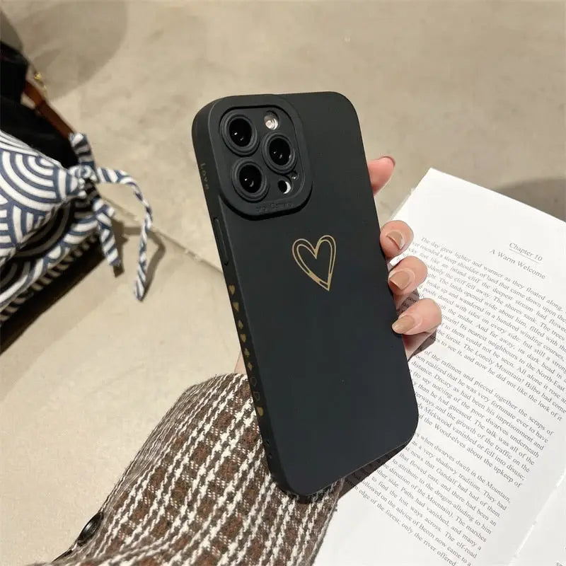 a person holding a black phone case with a heart on it