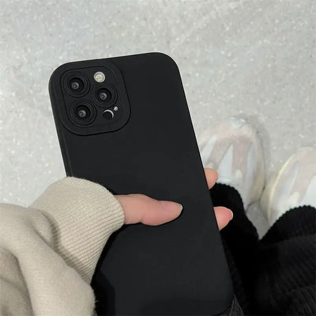 a person holding a black phone case