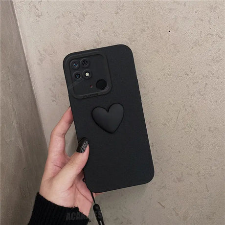 a hand holding a black iphone case with a heart on it