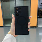 a woman holding up a black phone