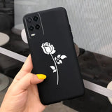 a hand holding a black phone case with a white rose on it