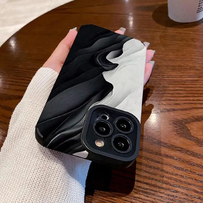 a hand holding a black and white phone case