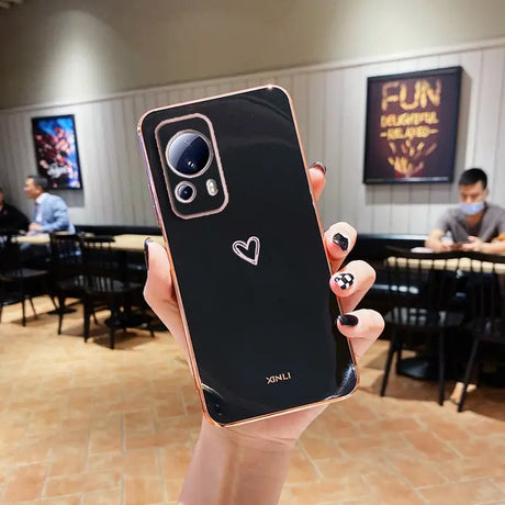 a person holding up a phone with a heart on it