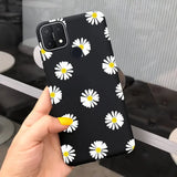 a person holding a black and white phone case with daisies on it