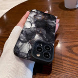 a woman holding a black and white marble phone case