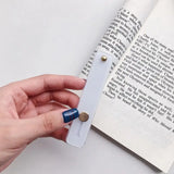 a person is holding a book with a bookmark