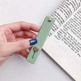 a hand holding a book with a bookmark