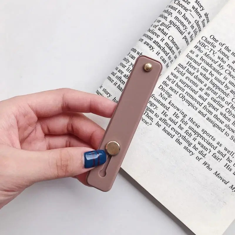 a hand holding a book with a bookmark