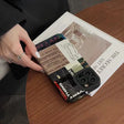 a person holding a camera on top of a table