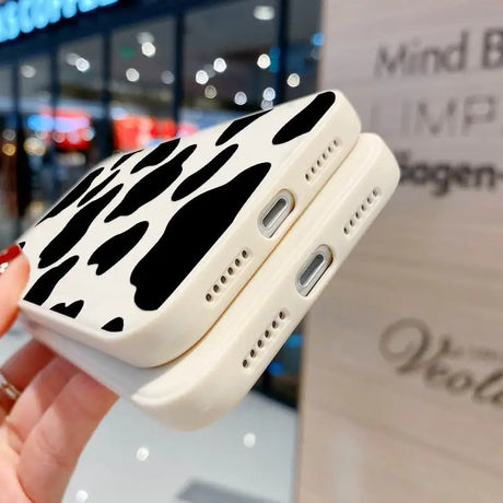 a hand holding a cell case with a cow print