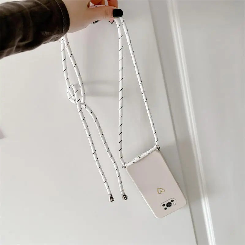 a person holding a white phone with a chain attached to it