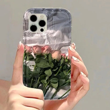 a woman holding a clear phone case with roses inside