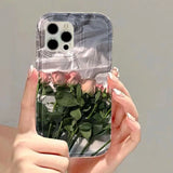 a woman holding a clear phone case with roses inside