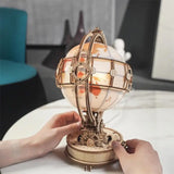 a person holding a globe on top of a table