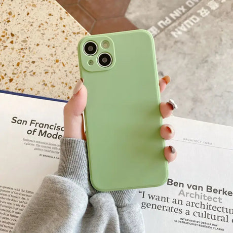 a woman holding a green iphone case