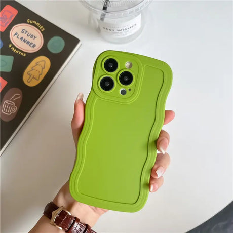 a person holding a green phone case