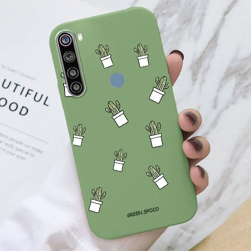a close up of a person holding a green phone case with cactus plants