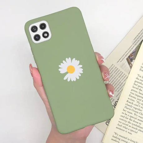 a woman holding a book and a green phone case