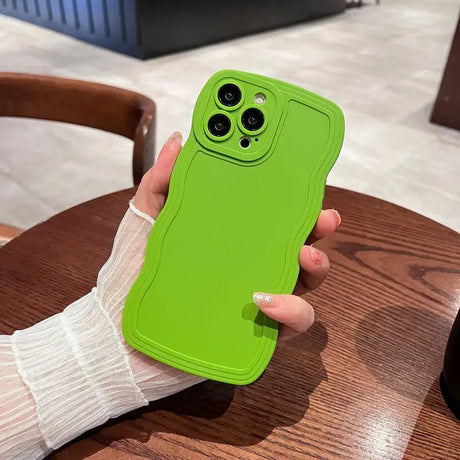 a person holding a green phone case