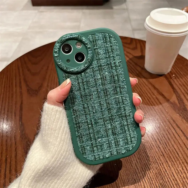 the green iphone case is held up on a wooden table