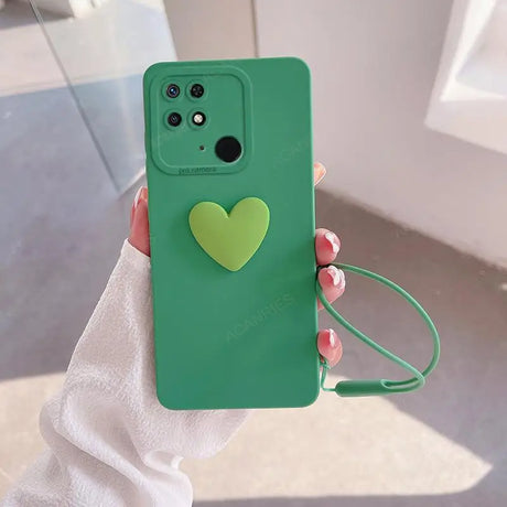 a person holding a green phone case with a heart on it