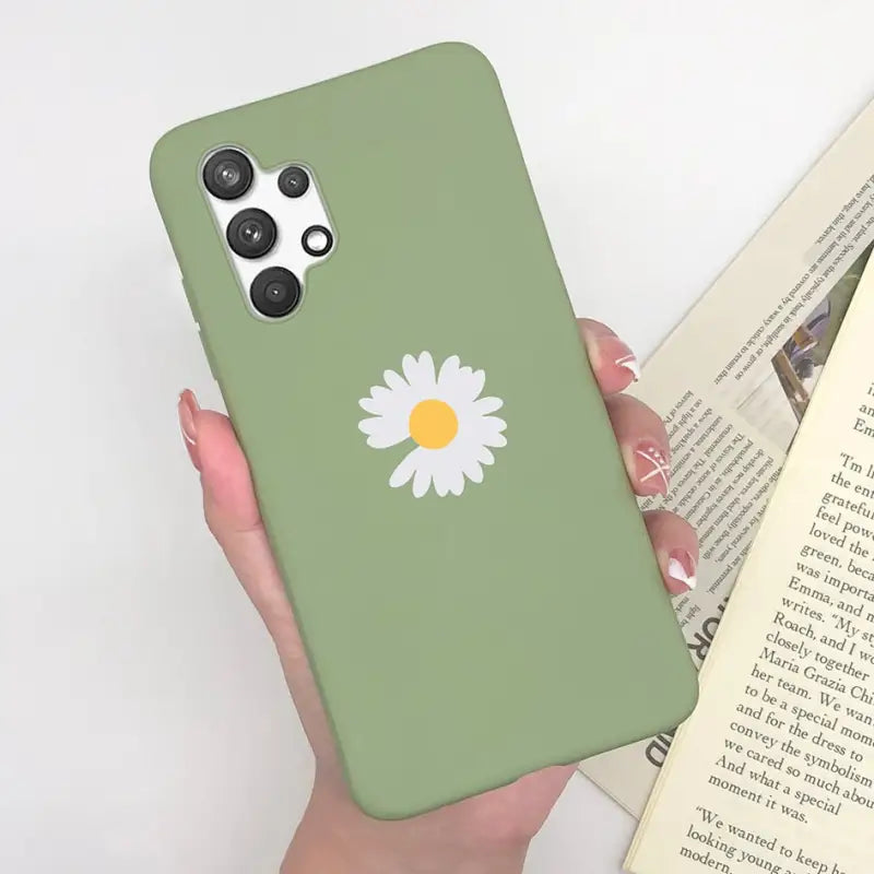 a person holding a green phone case with a daisy on it