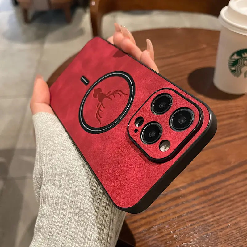 a person holding a red case with a black apple logo