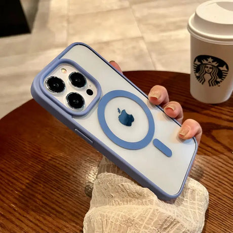 a person holding a phone case with a coffee cup in the background