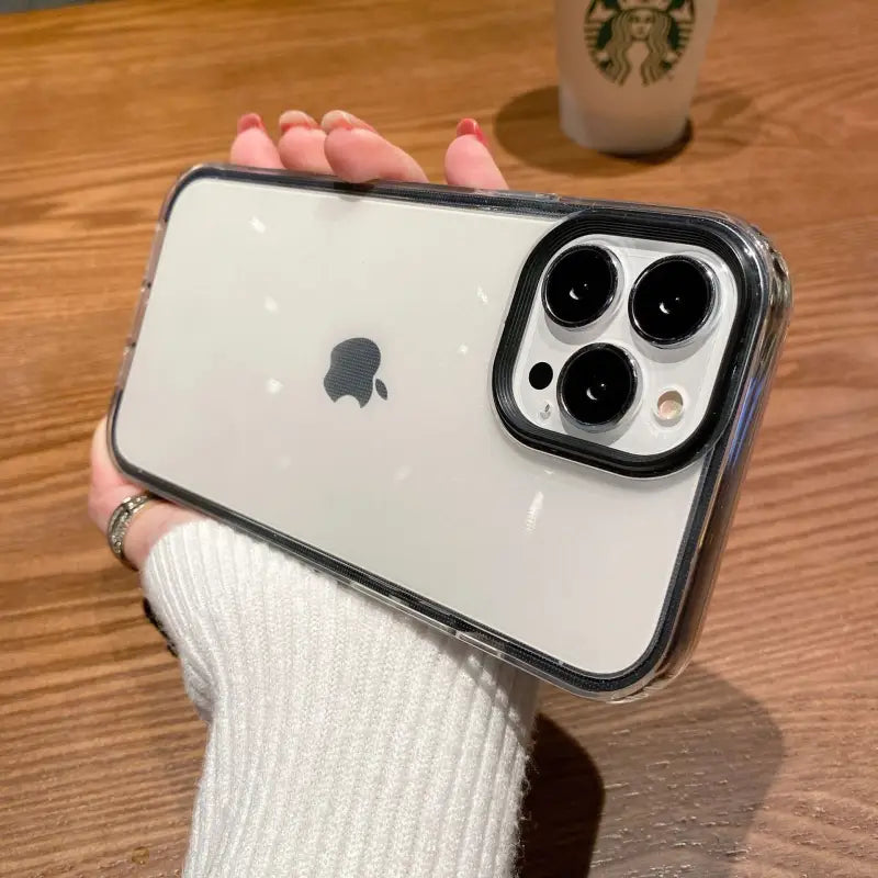 a person holding an iphone with a white sweater