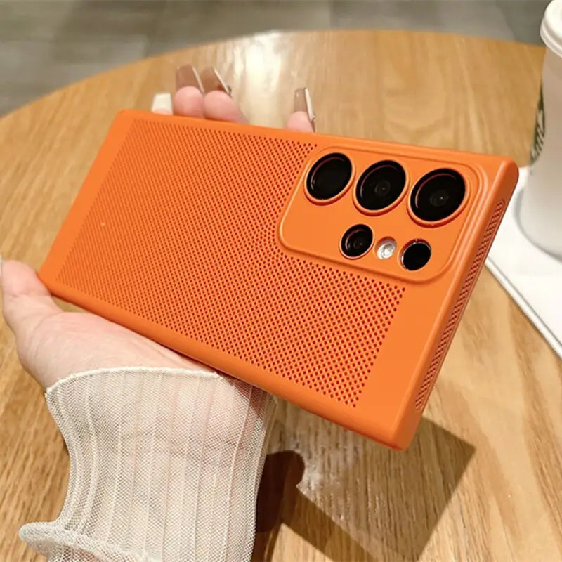 a person holding an orange phone case