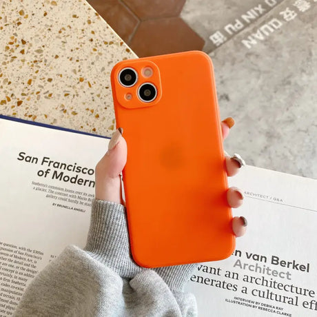 a person holding an orange iphone case