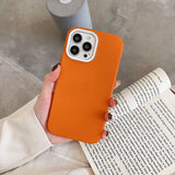 a person holding an orange iphone case