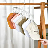 a person holding a pair of hats on a rack